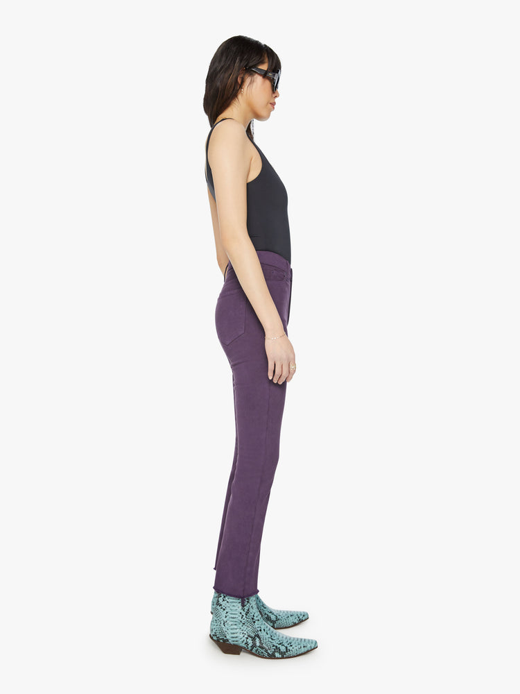 Side  view of a woman high-rise straight leg with an ankle-length inseam and a frayed hem in a blackberry-purple hue.
