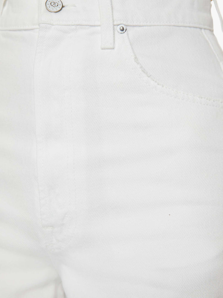 Swatch view of a woman in slouchy off-white jeans that have a super-high rise and feature a loose, full leg with a pretzel-detailed button.
