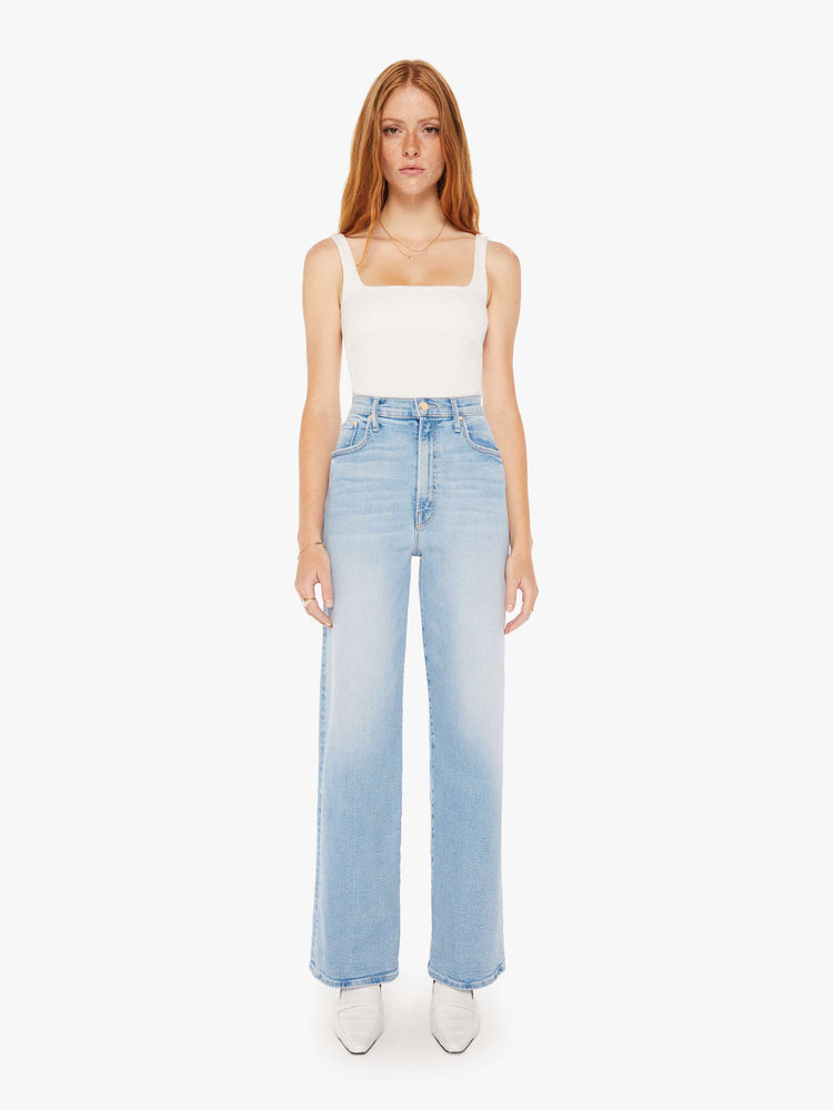 Front view of a woman super  high-waisted jeans with a loose fit, wide leg and 32-inch inseam with a clean hem in a light blue wash.