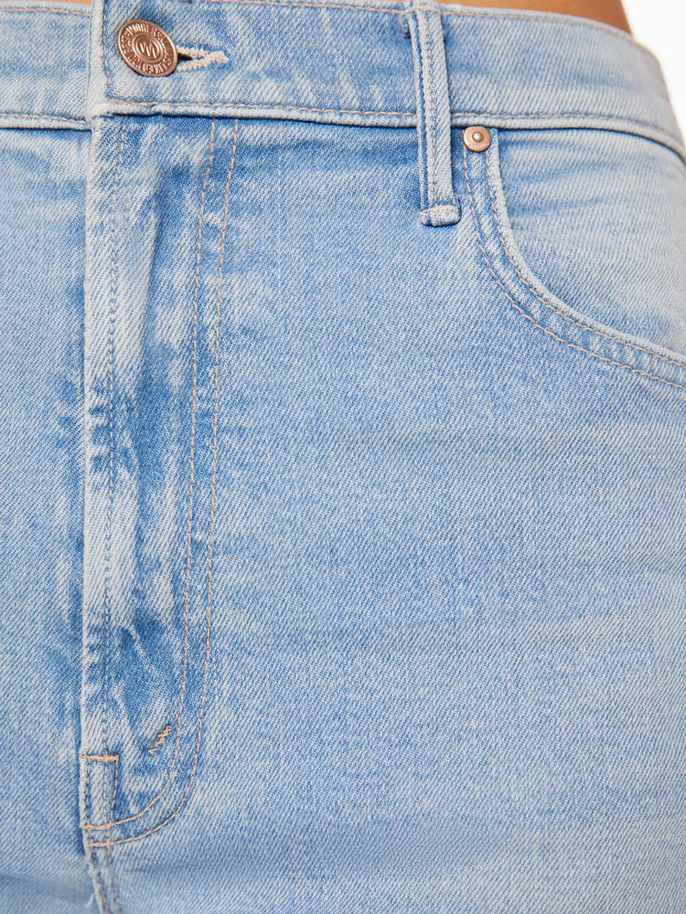 Swatch view of a woman in light blue super high-rise jeans with a loose fit, wide leg, zip fly and 32-inch inseam with a clean hem. 