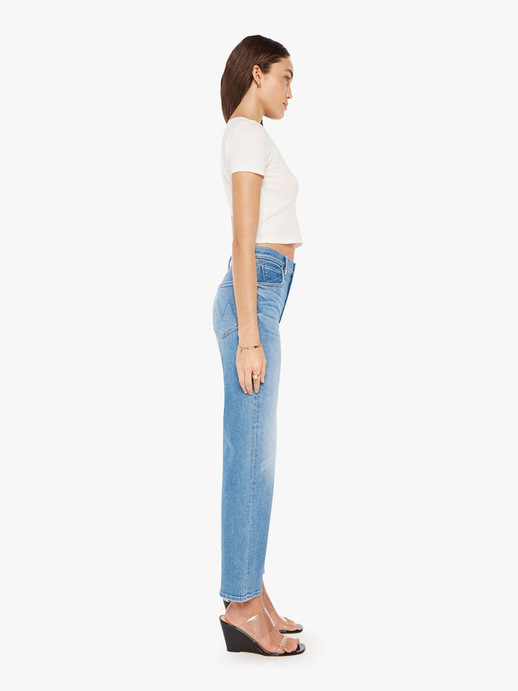 Side view of a woman high-waisted jean with a wide straight leg, zip fly and clean 28.25-inch inseam in a mid blue wash.