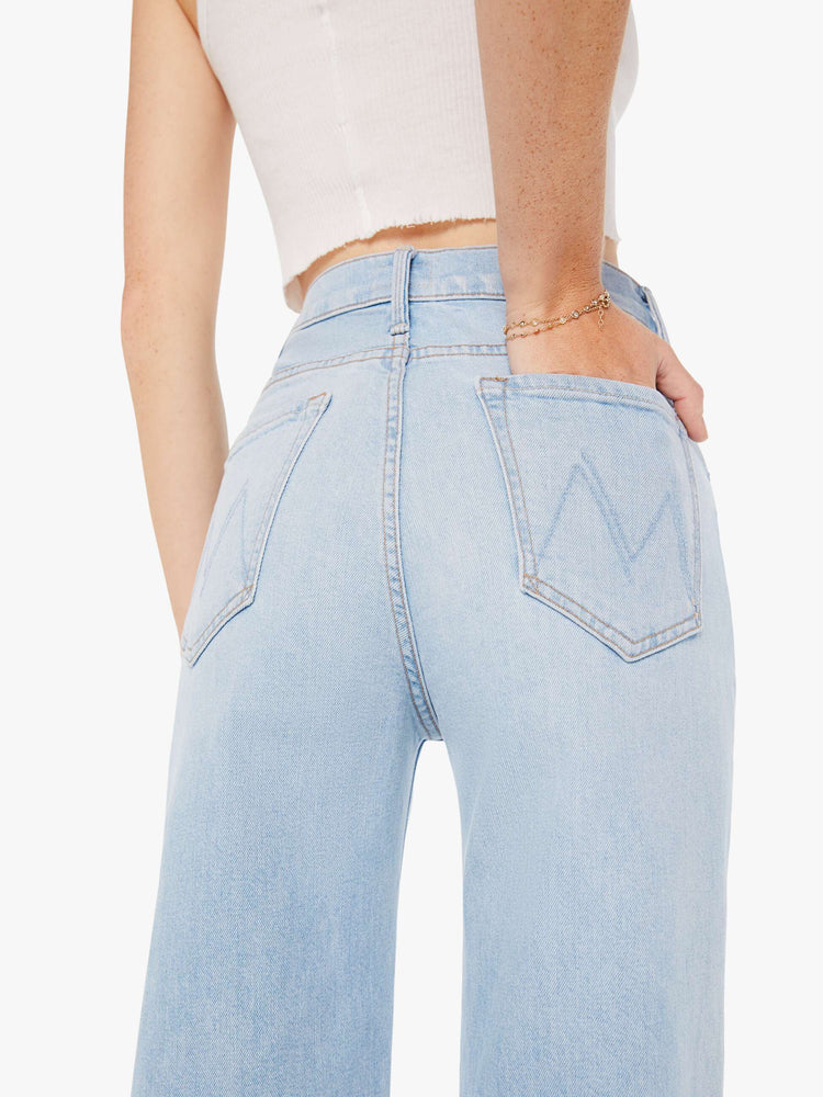 Back close up view of a womens light blue wash jean featuring a high rise and a wide straight leg.