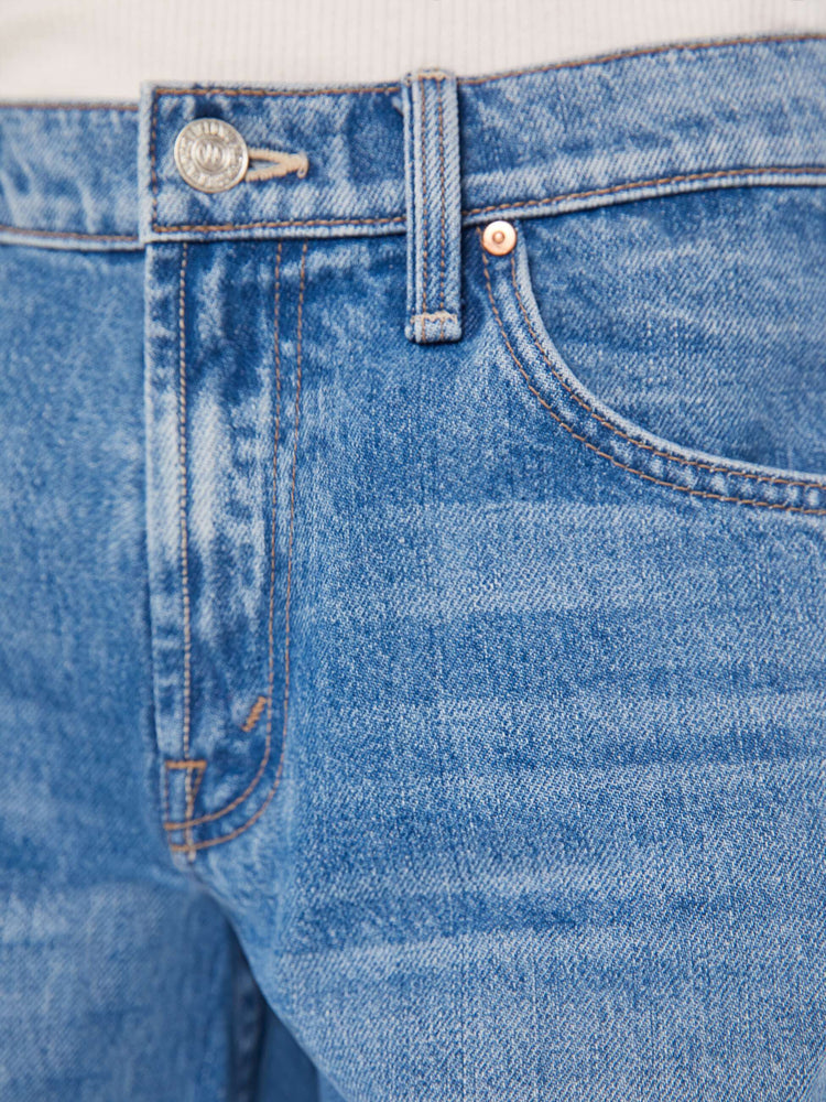 Swatch view of woman in a mid blue low-rise jeans with a loose wide leg and a long 32-inch inseam with a clean hem.