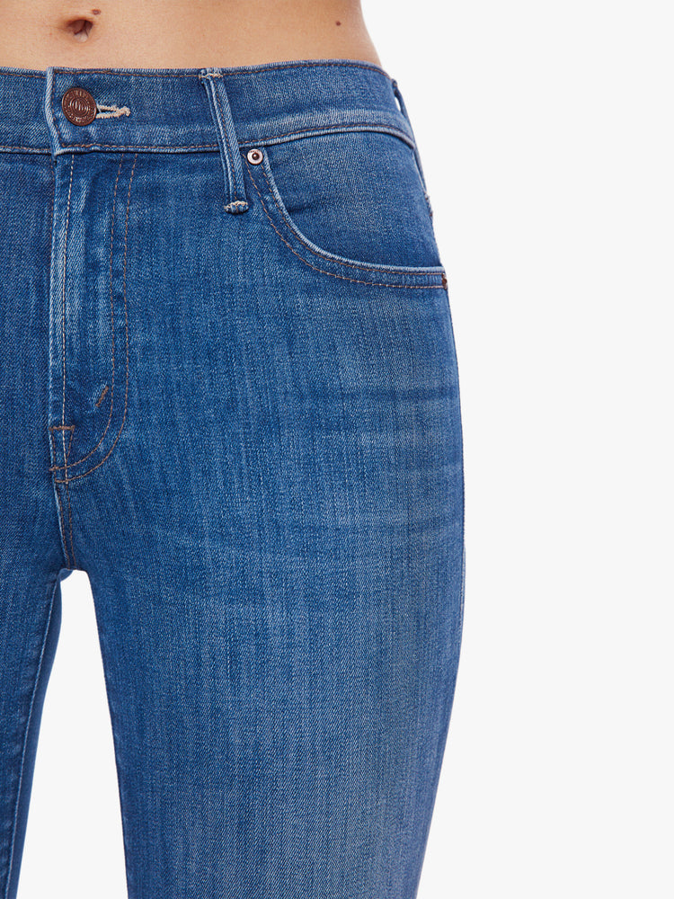 Swatch view of a woman mid-rise bootcut has a 34-inch inseam and a clean hem in a mid-blue wash.