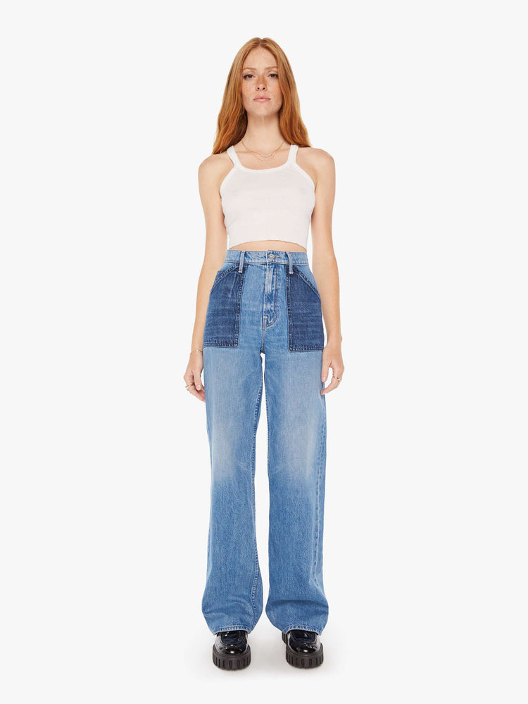 Front view of a woman super high-waisted jeans with a loose fit, wide leg, contrasting patch pockets and 34-inch inseam with a clean hem in a mid blue wash with darker denim pockets.
