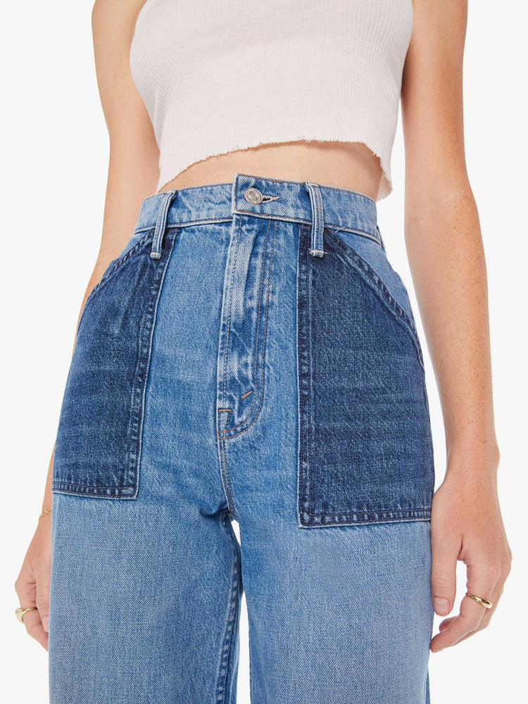 Waist close up view of a woman super high-waisted jeans with a loose fit, wide leg, contrasting patch pockets and 34-inch inseam with a clean hem in a mid blue wash with darker denim pockets.