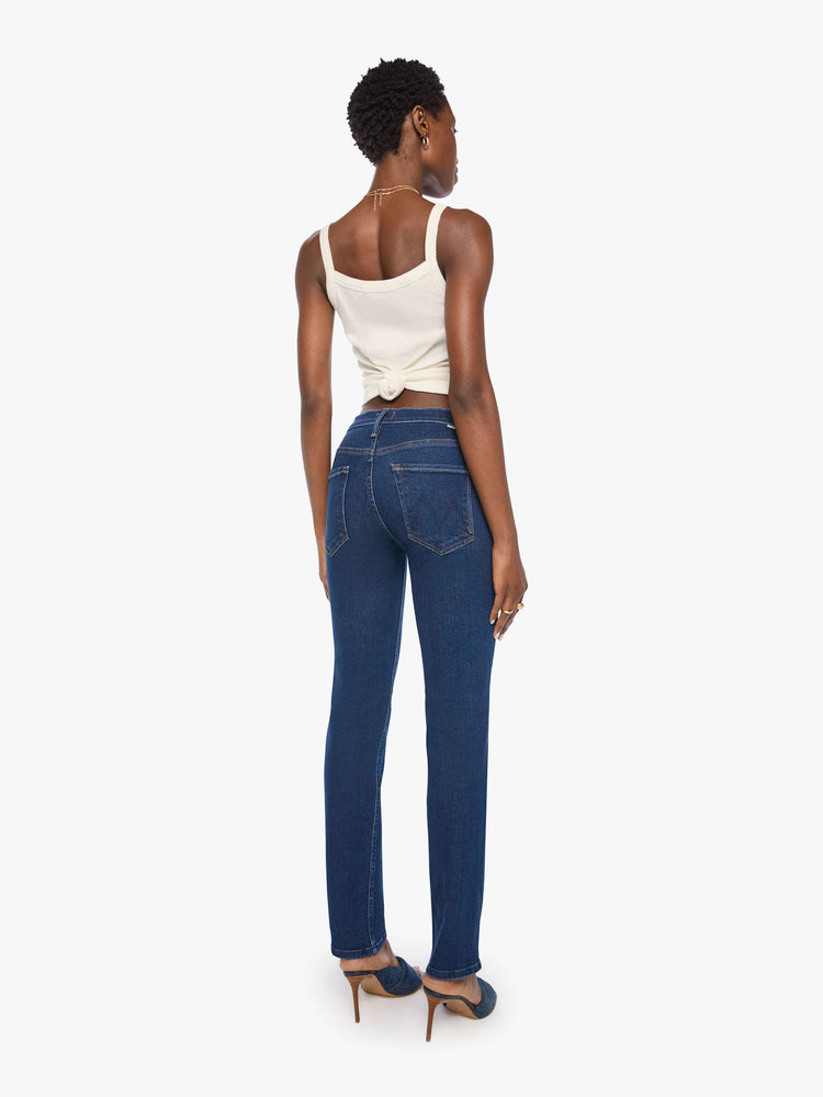 Back view of a woman in a dark blue mid-rise straight leg with a zip fly, 31-inch inseam and a clean hem.