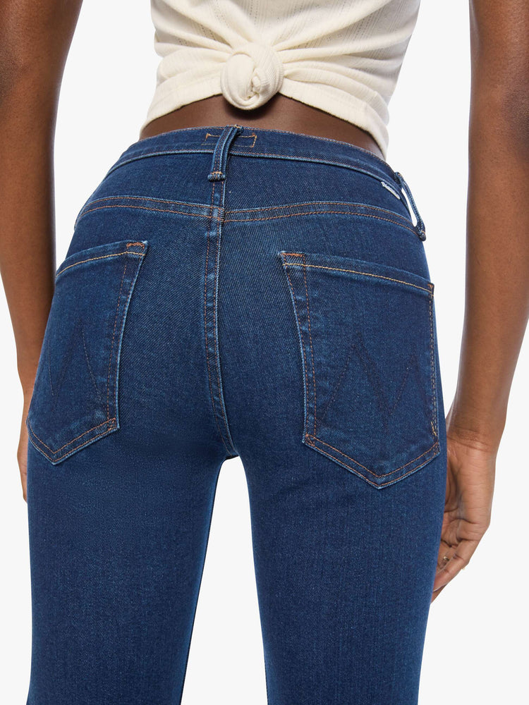 Close up view of a woman in a dark blue mid-rise straight leg with a zip fly, 31-inch inseam and a clean hem.