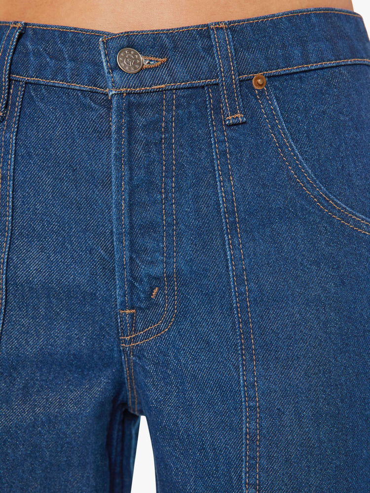 Front detail view of a womens dark blue denim jean featuring a long cuffed hem, a wide leg, carpenter details, and a loose slouchy fit.