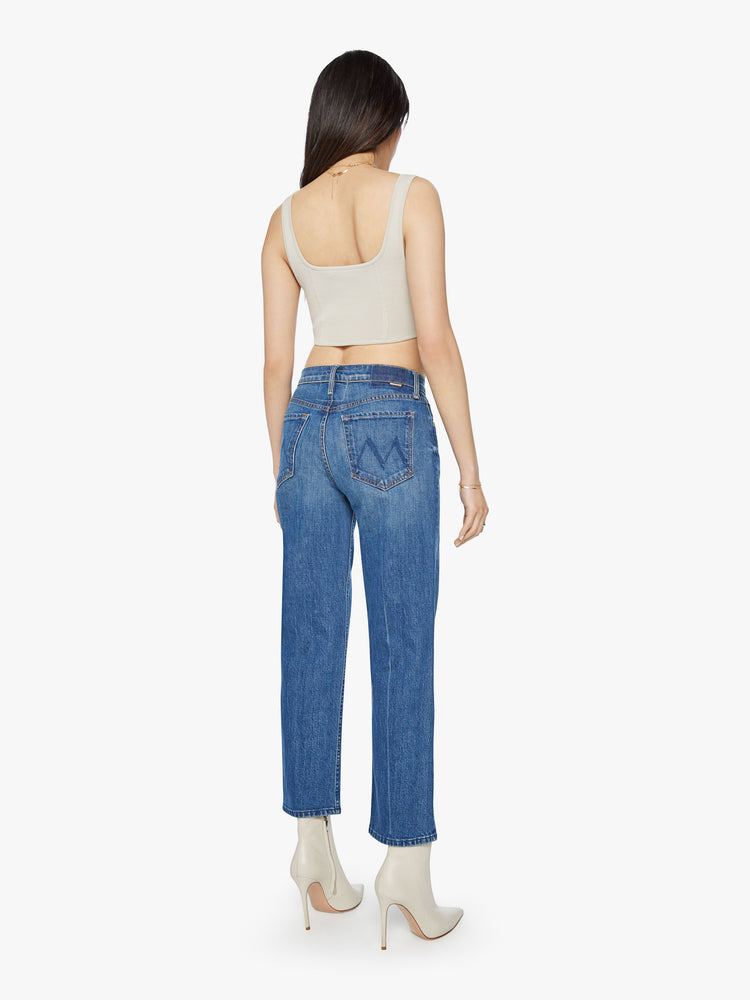 Back view of a woman classic blue jeans with a high rise, button fly, straight leg and a 31-inch inseam with a clean hem.