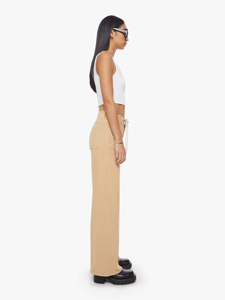 Side view of a woman wide-leg pant with a high rise, drawstring waistband and a 32-inch inseam with a clean hem in a sandy hue.
