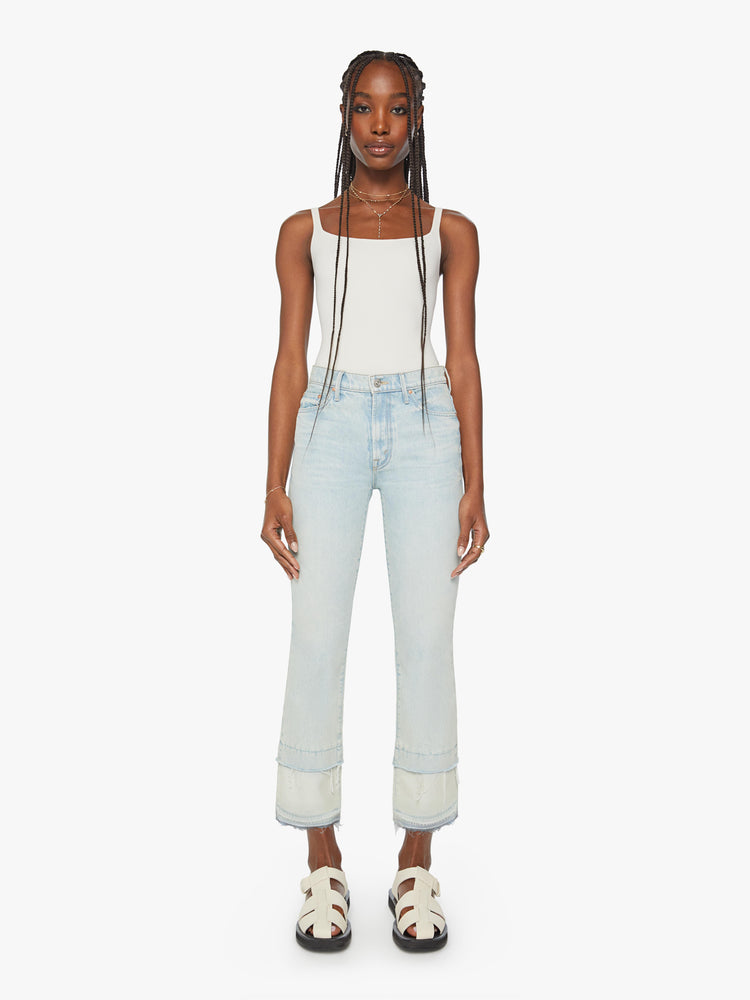 Front view of a woman light blue wash mid-rise bootcut has a 29-inch inseam and a frayed, double hem.