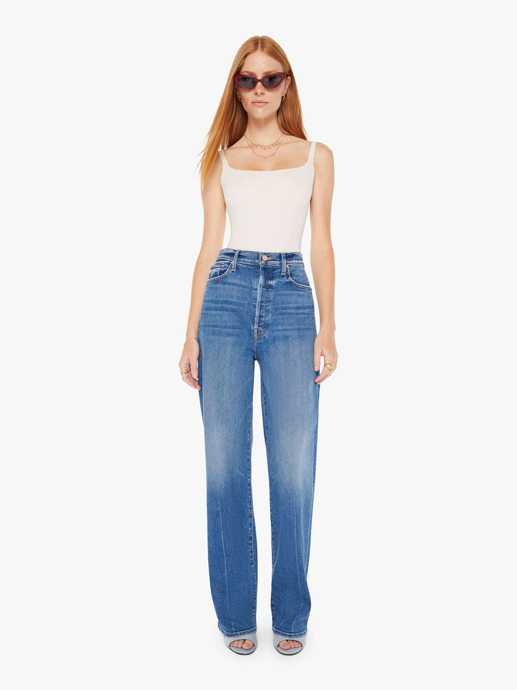 Front view of a womens medium blue wash jean featuring a super high rise and a wide full length leg.