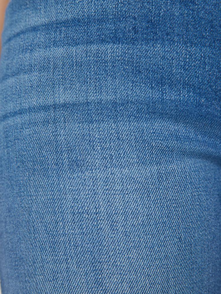 Swatch view of a woman high-rise flare with a long 34-inch inseam and a clean hem in a mid blue wash.