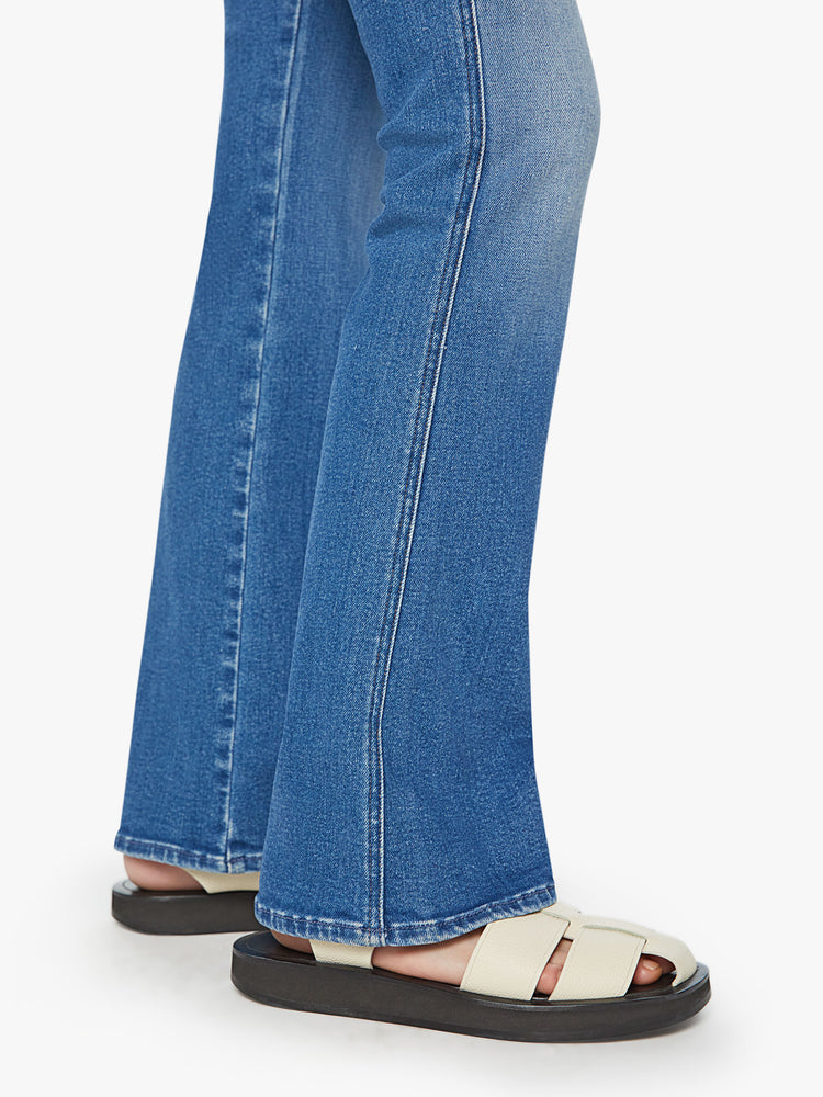 Hem view of a woman high-rise flare with a long 34-inch inseam and a clean hem in a mid blue wash.