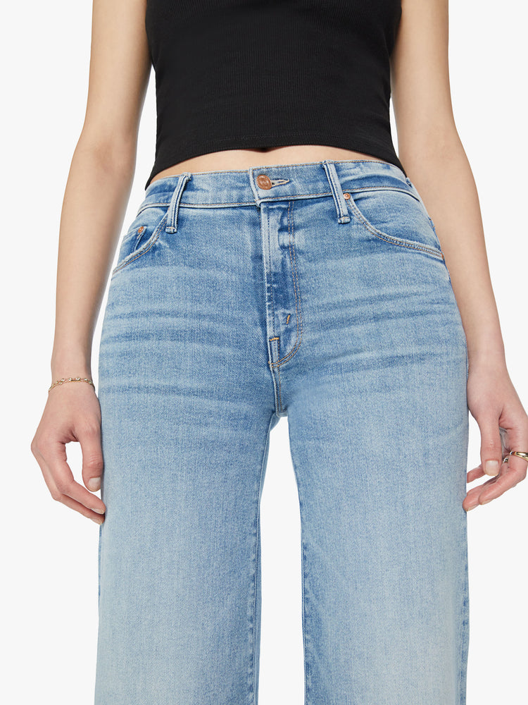 Close up view of a woman high-rise jeans with a wide leg and 31-inch inseam with a clean hem in a light blue wash.