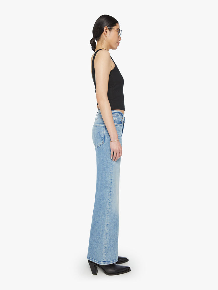 Side view of a woman high-rise jeans with a wide leg and 31-inch inseam with a clean hem in a light blue wash.