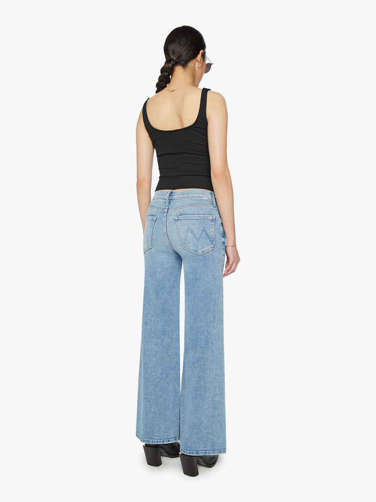 Back view of a woman high-rise jeans with a wide leg and 31-inch inseam with a clean hem in a light blue wash.