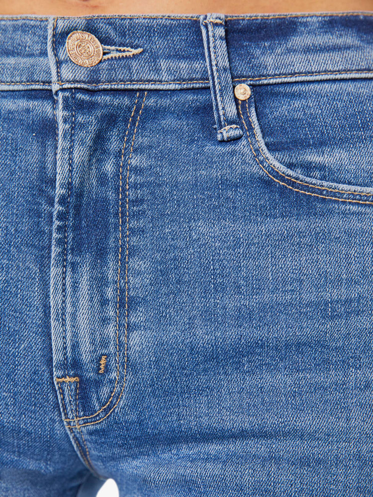 Swatch view of a woman in a mid blue high-rise pants with a flared, wide leg and 31-inch inseam with a clean hem.