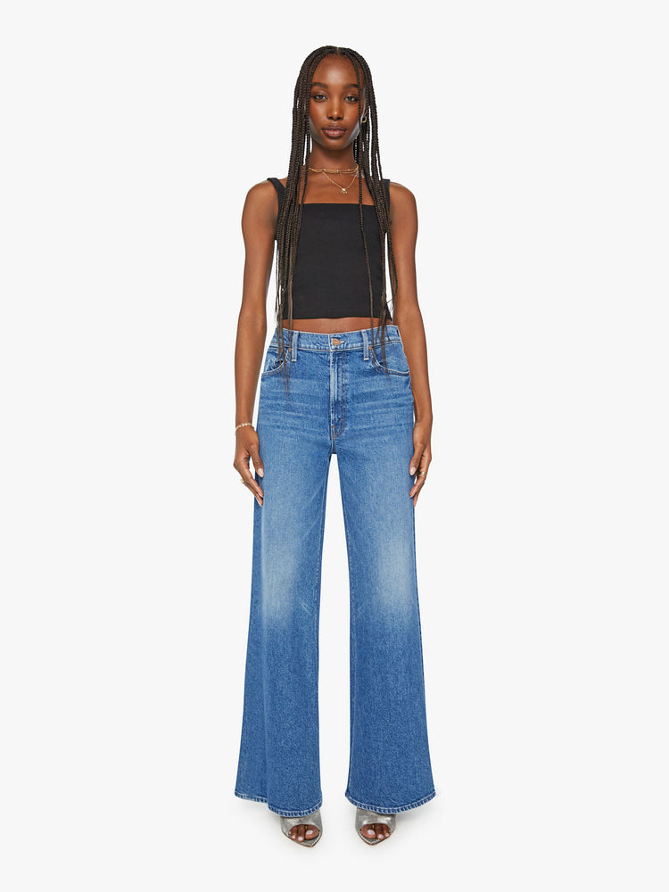 Front view of a woman wide leg jean with a zip fly, low-set back pockets, high-rise with a slouchy fit and a 32-inch inseam in mid blue wash.