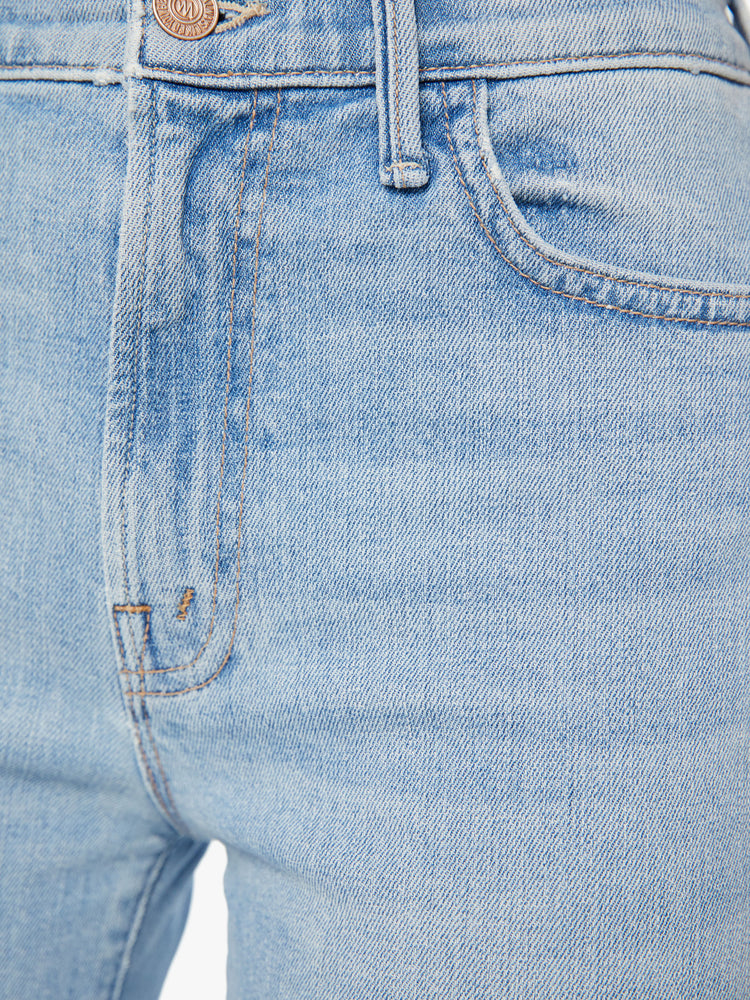 Swatch view of woman high-rise, straight-leg with an ankle-length inseam and a frayed hem in a light blue wash.