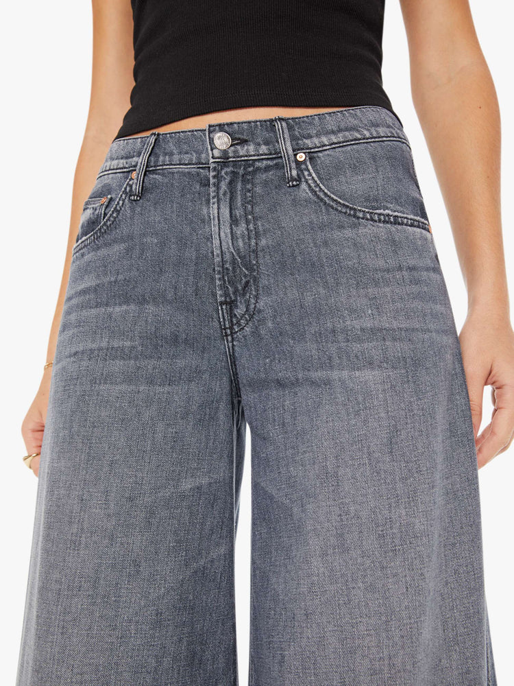 Front close up view of a womens grey wash jean featuring a high rise and a wide leg.