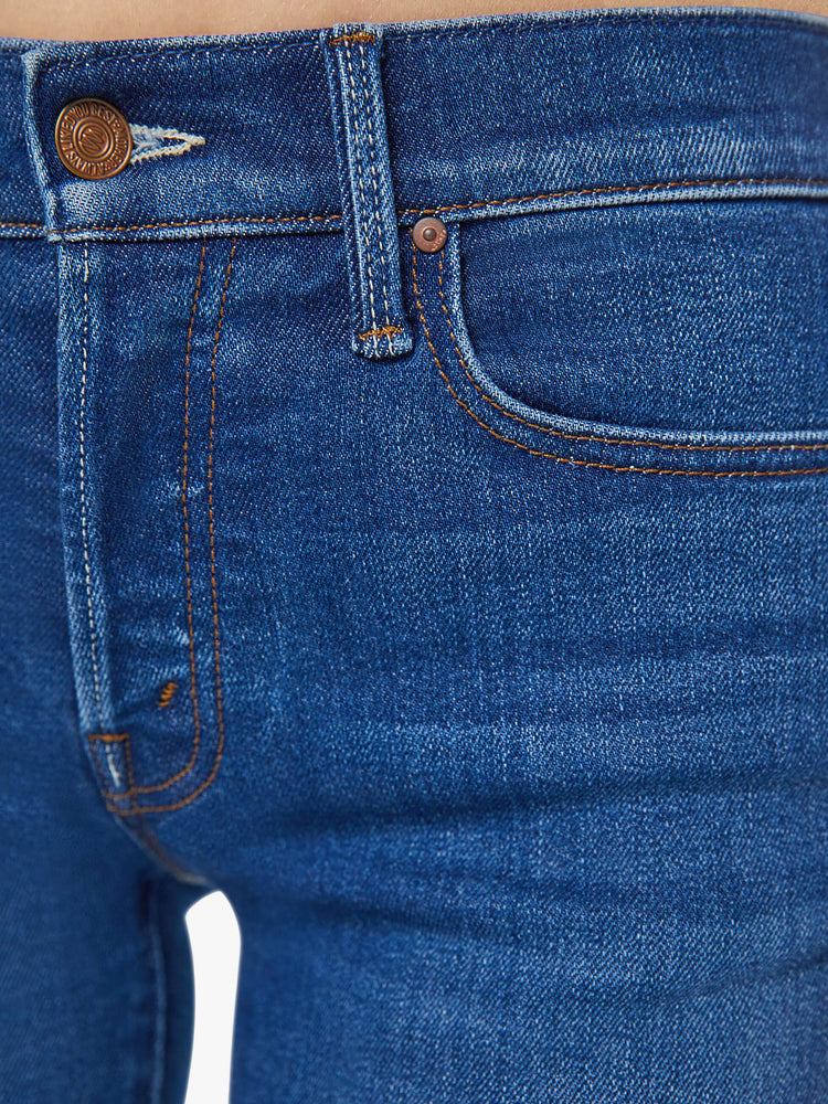 Detailed view of a woman in a dark blue straight-leg jean with super-subtle whiskering and fading at the knee.