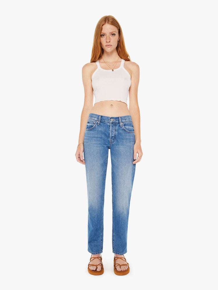 Front view of a womens medium blue wash jean featuring a mid rise with a slouchy fit and straight leg,
