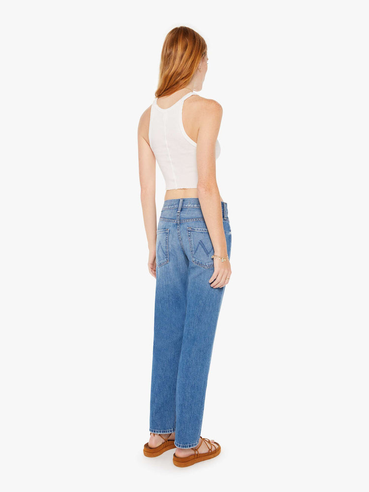 Back view of a womens medium blue wash jean featuring a mid rise with a slouchy fit and straight leg,