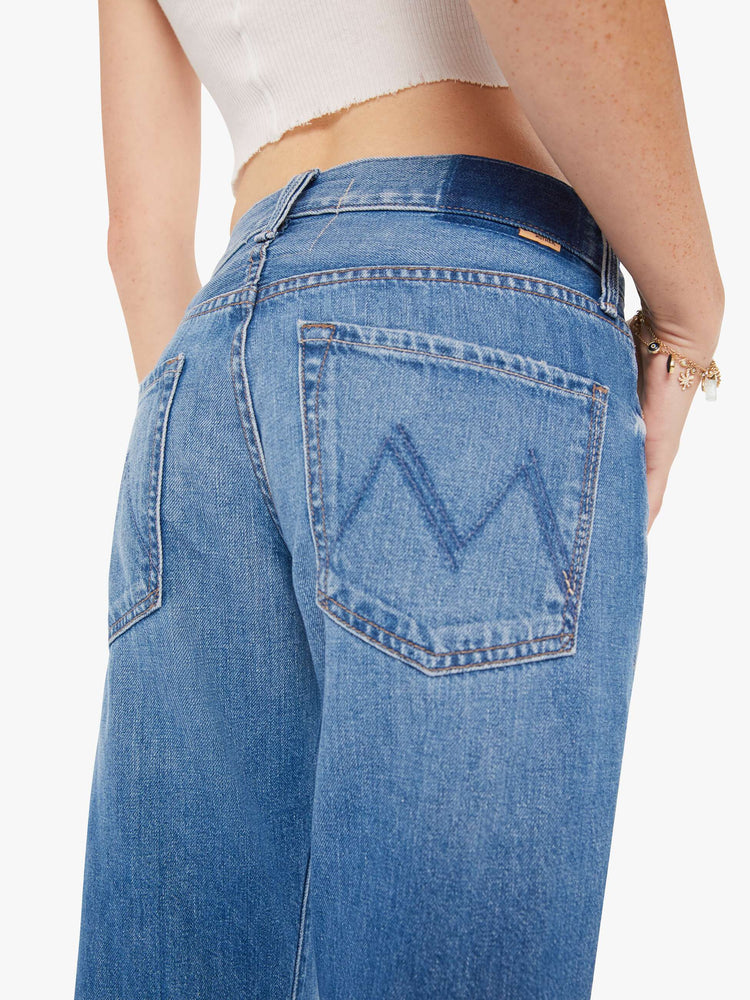 Back close up view of a womens medium blue wash jean featuring a mid rise with a slouchy fit and straight leg,