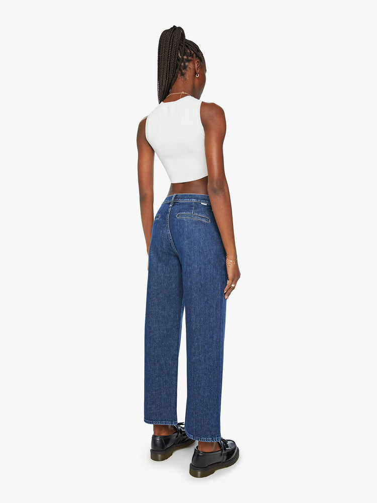 Back view of a woman high-waisted jeans with a loose wide leg, slit pockets and an ankle-length inseam in a dark blue wash.