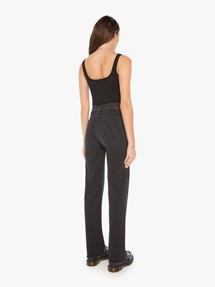 Back view of a woman black high-waisted jeans with a wide straight leg, patch pockets, zip fly and a long 32-inch inseam.