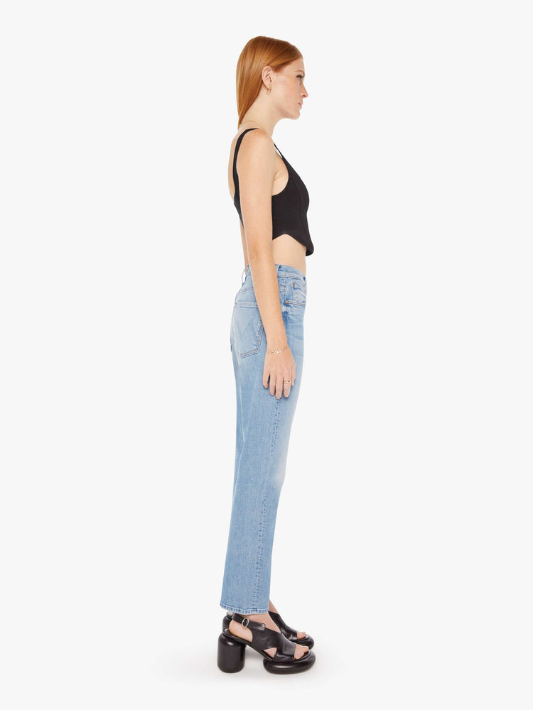 Side view of a womens light blue wash jean featuring a slouchy mid rise, straight leg, and a clean flood length hem.