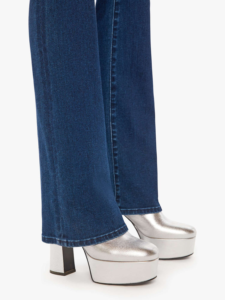 Hem view of a woman dark blue wash high-waisted flare jeans with a long 34-inch inseam and a clean hem.