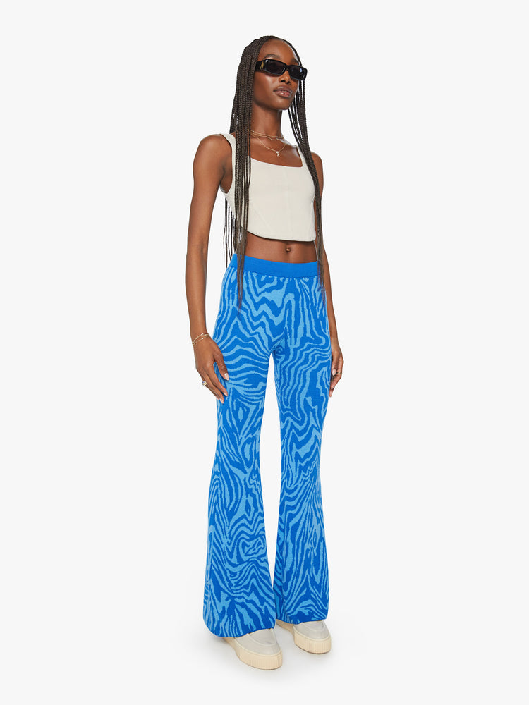 Angle front view of a woman high-waisted wide-leg flare with an elastic waist and a 31-inch inseam in blue zebra print.