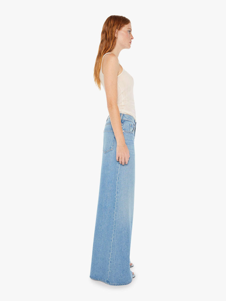 Side view of womens light blue jeans featuring a wide leg and relaxed slouch fit.