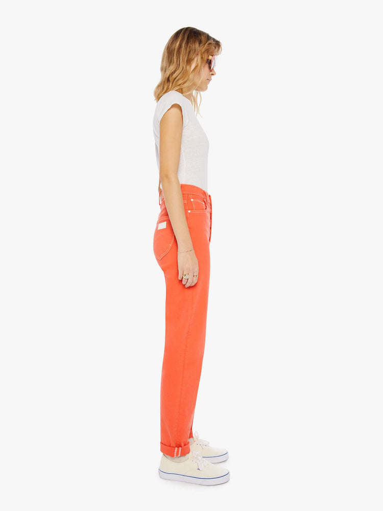 Side view of a womens bright coral jean featuring a super high rise and rolled cuff.