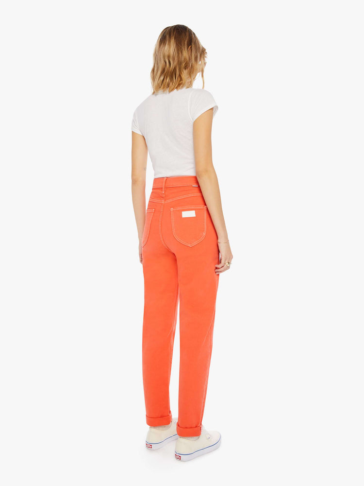 Back view of a womens bright coral jean featuring a super high rise and rolled cuff.