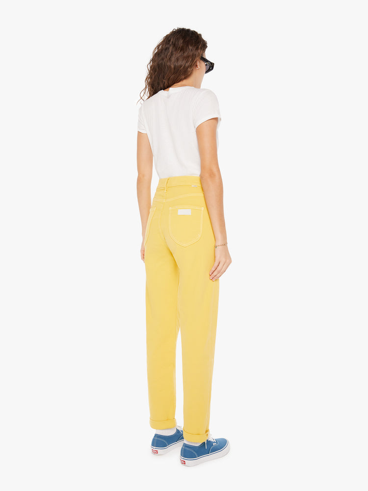 Back view of a womens yellow high rise jean featuring a cuffed hem.