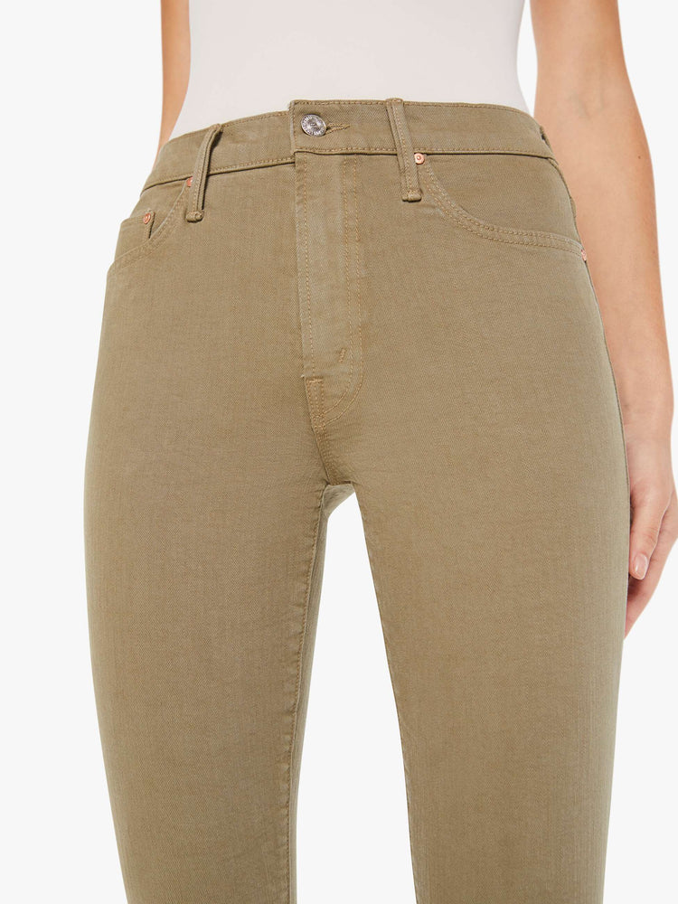 Front close up view of a womens greenish brown jean featuring a high rise.