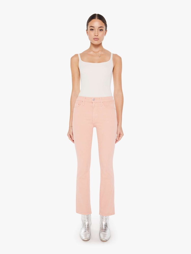 Front view of a womens faded pink jean featuring a high rise and a bootcut leg with clean hem.