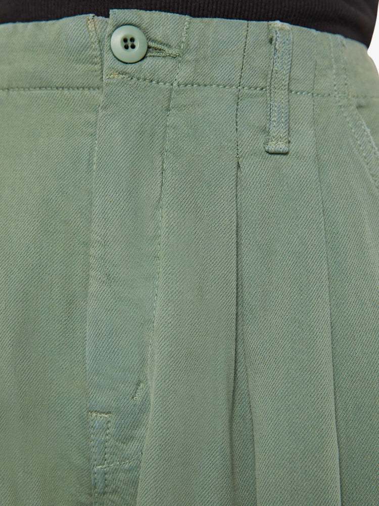 Close up swatch detail view of an army green pant with front pleats.