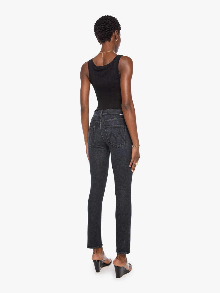 Back view of a woman in a black mid-rise straight leg jean with a zip fly, 31-inch inseam and a clean hem.