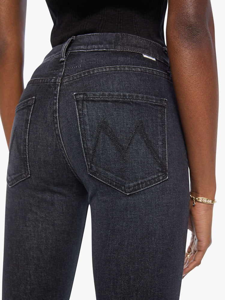 Close up view of a woman in a black mid-rise straight leg jean with a zip fly, 31-inch inseam and a clean hem.