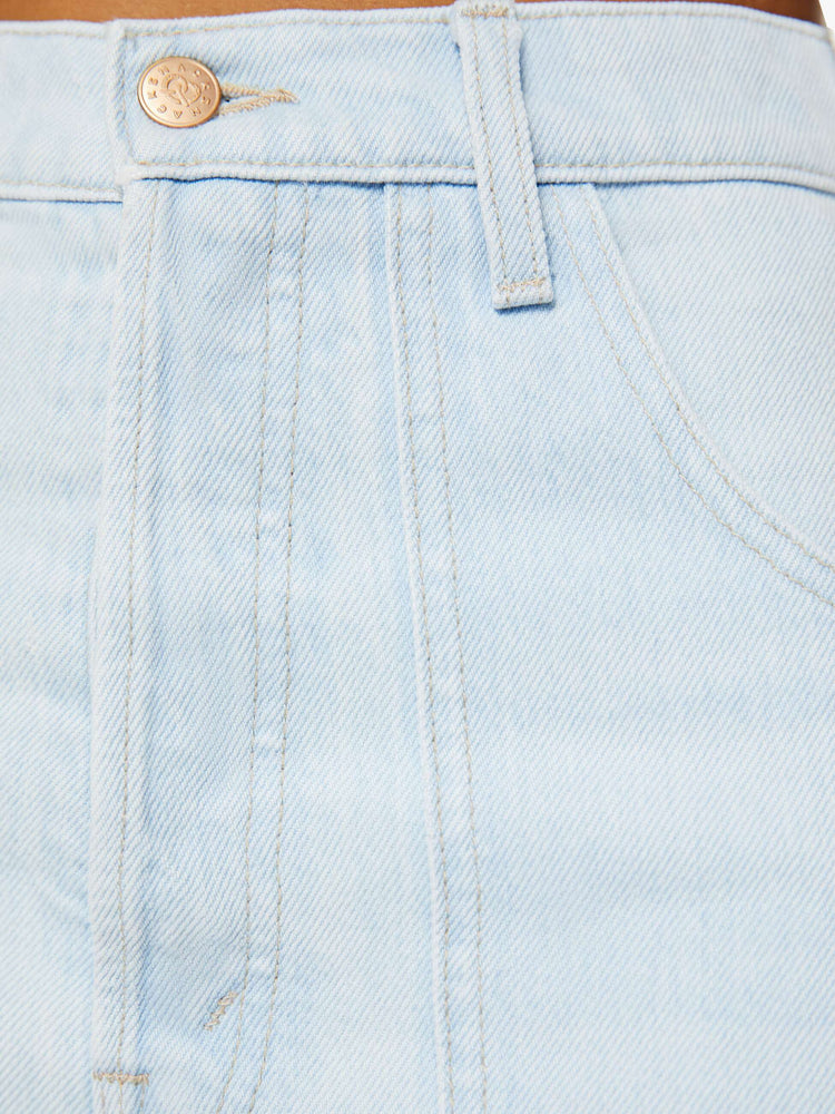 Swatch view of a woman in light blue super high-rise jeans, designed with a button-fly, workwear-inspired patch pockets, a hammer loop, ankle-length inseam and slouchy fit with a pretzel-detailed button.