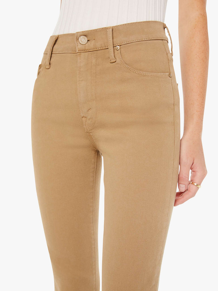 Front close up view of a womens brown pant featuring a mid rise and long flare leg,