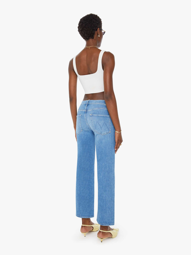 Back view of a woman mid blue wash mid-rise jeans with a wide straight leg, zip fly and clean ankle-length inseam.