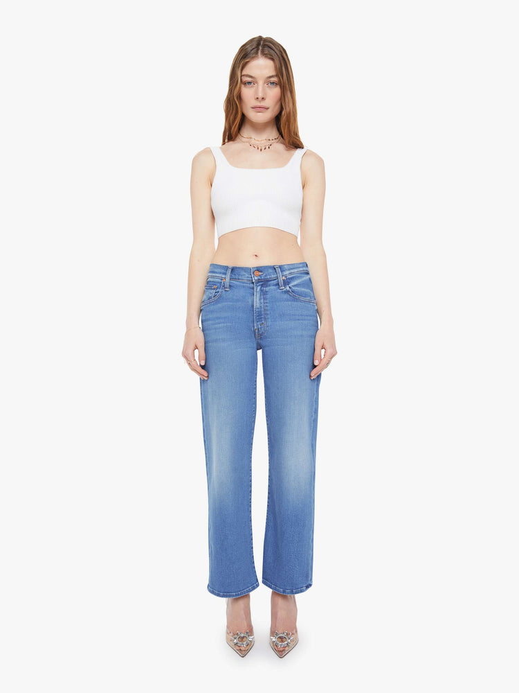 Front view of woman in a mid blue mid-rise jeans with a wide straight leg, zip fly and clean ankle-length inseam.