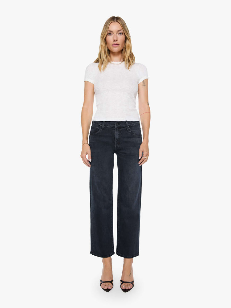 Front view of a woman in a dark denim mid-rise jean with a wide straight leg, zip fly and clean ankle-length inseam. 