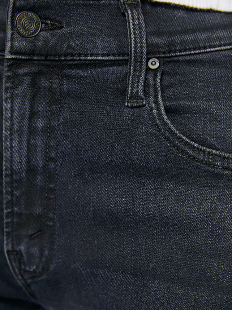 Swatch view of a woman in a dark denim mid-rise jean with a wide straight leg, zip fly and clean ankle-length inseam. 